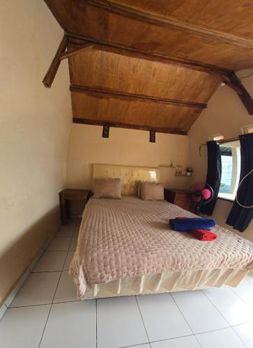 a bedroom with a bed with a wooden ceiling at Senaru sunset house in Senaru