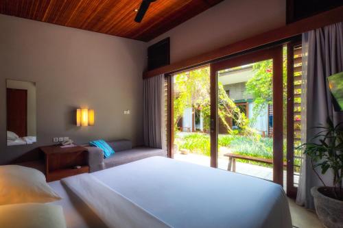 Un pat sau paturi într-o cameră la Hotel Komune and Beach Club Bali