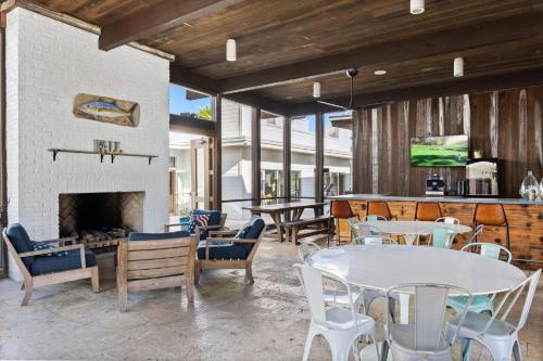 a living room with tables and chairs and a fireplace at Sand Pointe by 30A Escapes in Inlet Beach