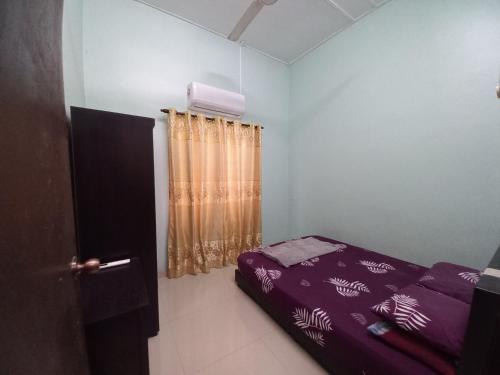 a bedroom with a purple bed and a window at Homestay DC 1 - wifi, netflix in Shah Alam