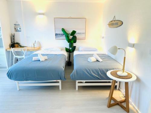 a room with two beds and a table and a plant at HolidayRento Bondi Rooftop Pool & Air Con Studio in Sydney