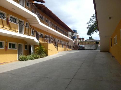 an empty courtyard of a building with a car parked at Hotel Portal do Éden in Sorocaba