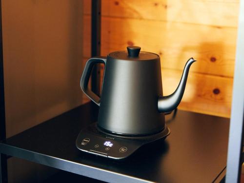 a black tea kettle sitting on top of a counter at Mission Hills Hotel in Minano