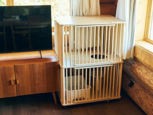 a wooden bird cage sitting next to a television at Mission Hills Hotel in Minano