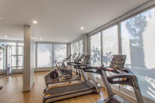 einen Fitnessraum mit 3 Cardio-Geräten in einem Zimmer mit Fenstern in der Unterkunft B9 Ватсап669З5В2I976 in Nai Yang Beach