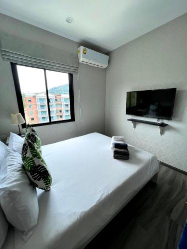 a bedroom with a white bed and a flat screen tv at B9 Ватсап669З5В2I976 in Nai Yang Beach