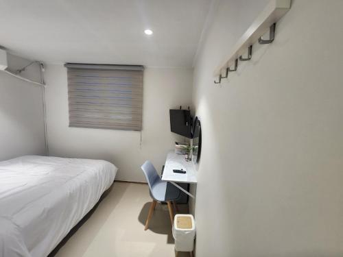 a bedroom with a bed and a desk with a chair at Stay Jakjeon in Incheon