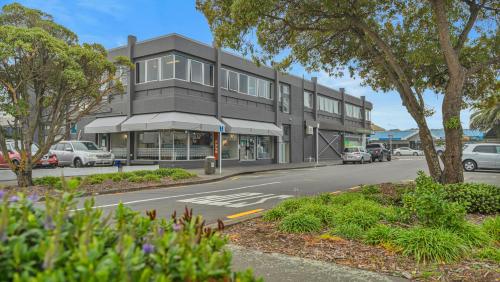 a building on a street with cars parked in front of it at Christchurch Backpackers in Christchurch