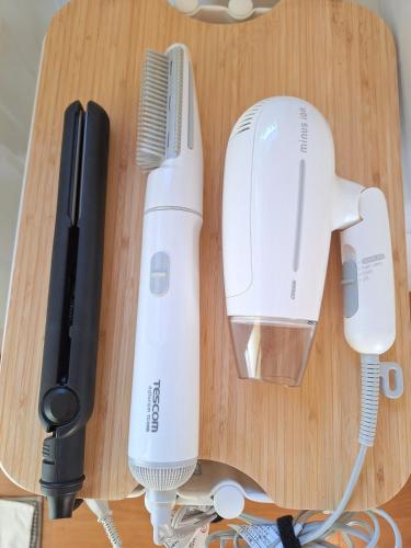 a table with two hair brushes and a hair dryer at Peaceful Garden Home in Ota, Entire 3BR Parking in Ota