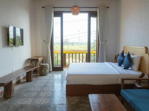 a bedroom with a bed and a large window at Aki Eco-villa Hội An in An Bang