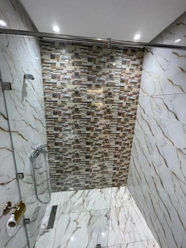 a bathroom with a shower with a stone wall at Apartment in a beachfront complex in Casablanca