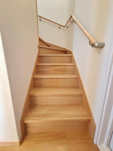 a stairwell with wooden stairs with a rail at Peaceful Garden Home in Ota, Entire 3BR Parking in Ota