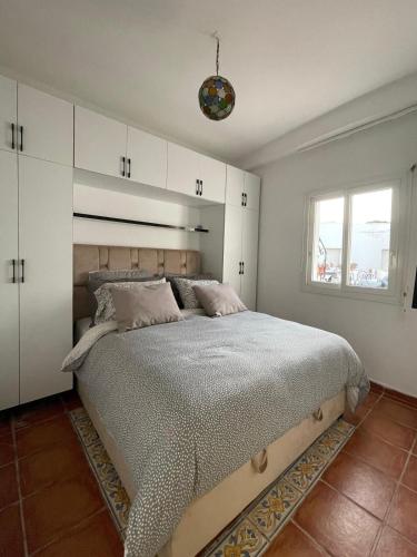 a bedroom with a large bed with white cabinets at Apartment in a beachfront complex in Casablanca