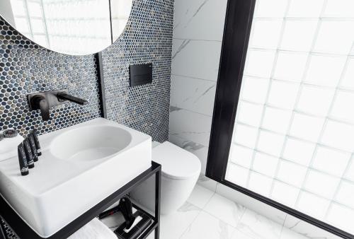 a bathroom with a sink and a toilet and a mirror at Brady Hotels Jones Lane in Melbourne