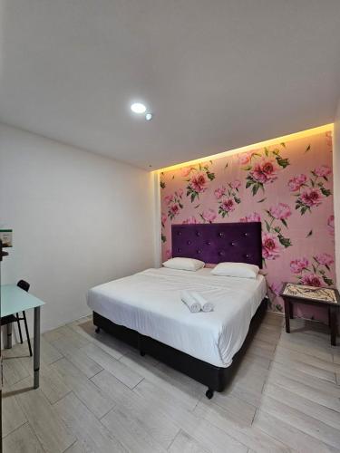a bedroom with a bed with a floral wall at V Garden Hotel by Minsu in Kuala Lumpur