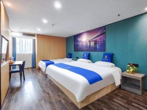 a bedroom with two large beds with blue walls at Super 8 Hotel Xiamen Railway Station in Xiamen