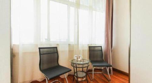 two chairs and a table in a room with a window at Super 8 Hotel Jinan Railway Station Square in Jinan