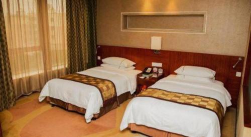 a hotel room with two beds in a room at Jinhua World Trade Hotel in Jinhua