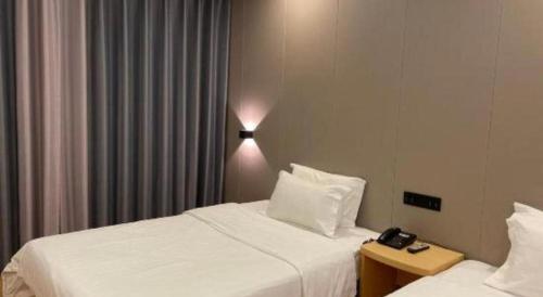 Postel nebo postele na pokoji v ubytování 7 Days Inn Fucheng Wu Gongci Gaodeng East Street Binjiang Road