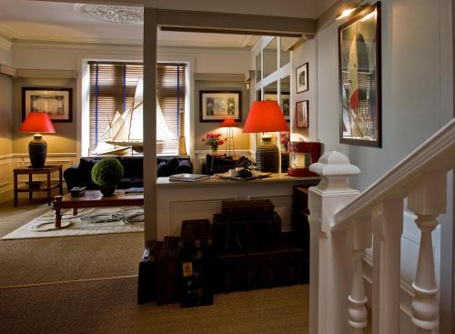a living room with a staircase with red lamps at Le Petit Hôtel des Hortensias in La Trinité-sur-Mer