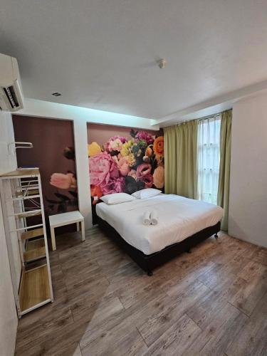 a bedroom with a large bed with a flower mural at V Garden Hotel by Minsu in Kuala Lumpur