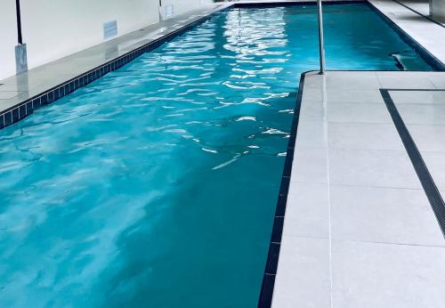 una piscina con agua azul en un edificio en PISTE LUXURY CHALET - Lake Crackenback Resort, en Crackenback