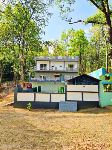 a house in the middle of a field with a building at Forest Retreat Khalanga in Rāipur