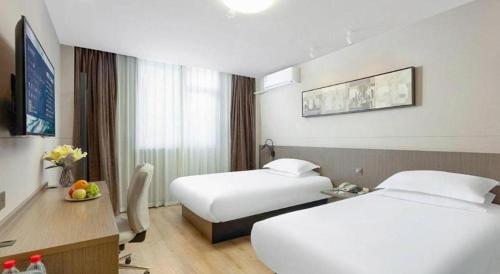 a hotel room with two beds and a table at Jinjiang Inn Select Tianjin Xiaobailou Metro Station in Tianjin