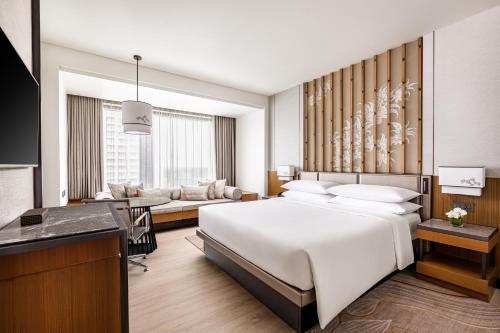 a bedroom with a large white bed and a desk at Chiang Mai Marriott Hotel in Chiang Mai