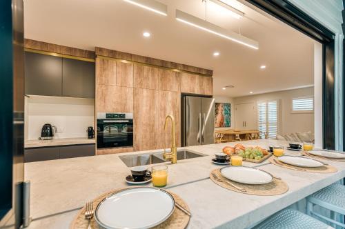 a kitchen with a counter with three plates on it at Essence Peregian Beach in Peregian Beach