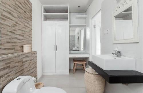 a white bathroom with a sink and a toilet at Central Seminyak Private 3 Bedroom Villa Roshi in Seminyak