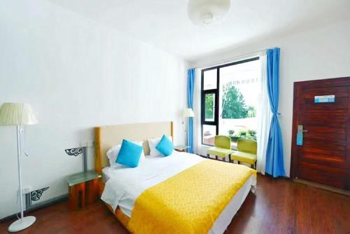 a bedroom with a bed with blue and yellow sheets at Erhaike Seaview Inn in Dali