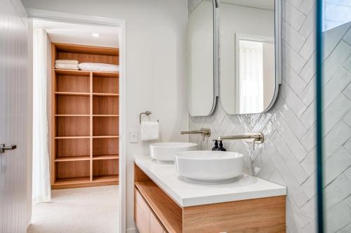 a bathroom with two sinks and a mirror at Essence Peregian Beach in Peregian Beach