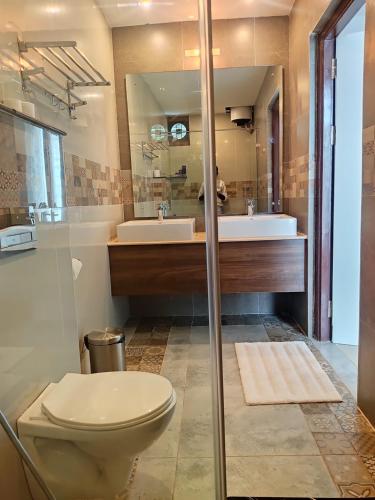 a bathroom with a toilet and a sink at Montecarlo Hotel in Mahabalipuram