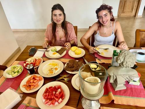 two women sitting at a table with plates of food at Star Light Tropical Villa in Bentota