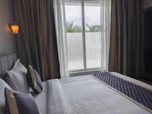 a bedroom with a bed and a large window at Montecarlo Hotel in Mahabalipuram