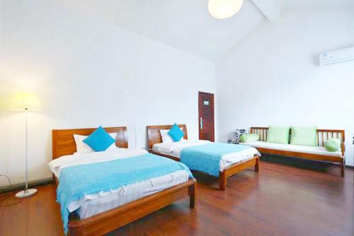 a bedroom with two beds and a couch in it at Erhaike Seaview Inn in Dali