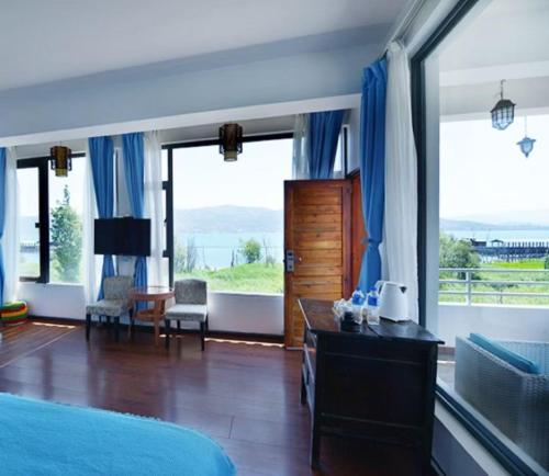 a bedroom with a bed and a large window at Erhaike Seaview Inn in Dali