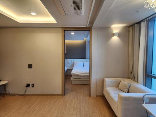 a living room with a couch and a bedroom at Elbon the stay with A1 in Busan