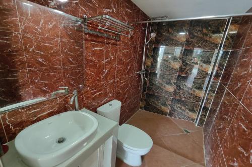 a bathroom with a toilet and a sink and a shower at Elicon Suites Resort Bohol near City Center in Tagbilaran City
