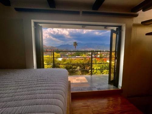 a bedroom with a large window with a view at El mirador E&A en el Centro Histórico de Oaxaca y vistas a las montañas in Oaxaca City