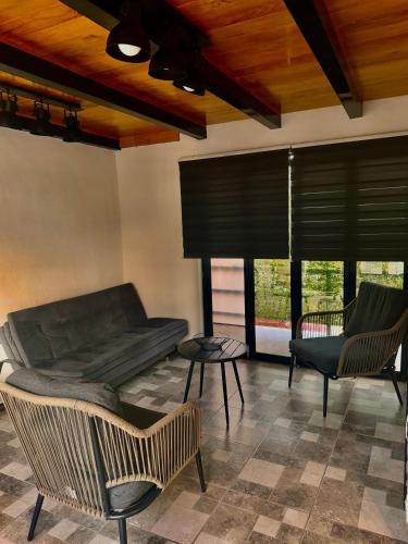 a living room with a couch and chairs and windows at El mirador E&A en el Centro Histórico de Oaxaca y vistas a las montañas in Oaxaca City