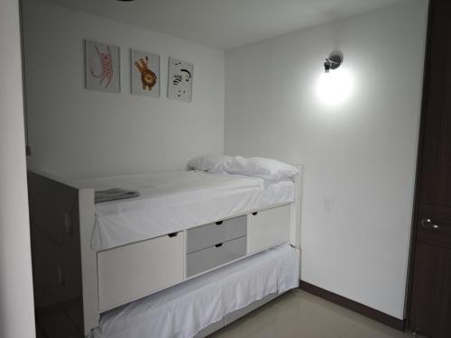 a white bedroom with a bed and a wall at AquaLuxe Apto, Aire-Acondicionado, balcon, cocina - hasta 7 Personas in Villeta