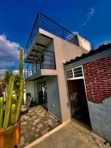 a house with a cactus in front of it at El mirador E&A en el Centro Histórico de Oaxaca y vistas a las montañas in Oaxaca City