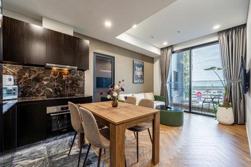 a kitchen and living room with a wooden table and chairs at LUMIERE RIVERSIDE LUXURY APARTMENT 5STar in Ho Chi Minh City