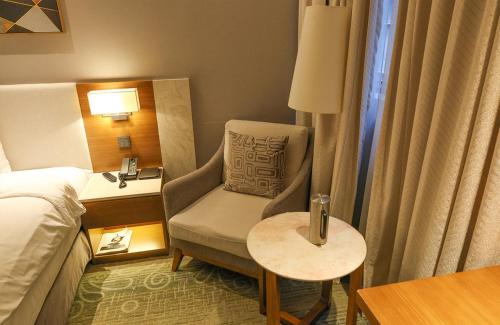 a hotel room with a chair and a table at Hotel Skypark Central Seoul Pangyo in Seongnam