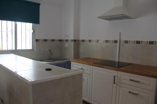 a kitchen with white cabinets and a sink at Studio Tropical in Cúllar-Vega