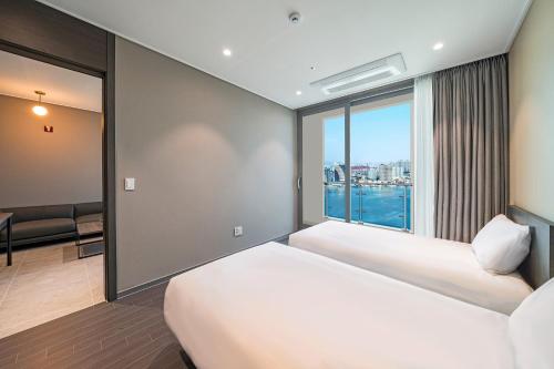 a hotel room with two beds and a window at Sokcho Mari Vista Hotel in Sokcho
