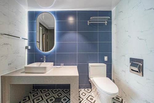 a bathroom with a sink and a toilet and a mirror at Sokcho Mari Vista Hotel in Sokcho
