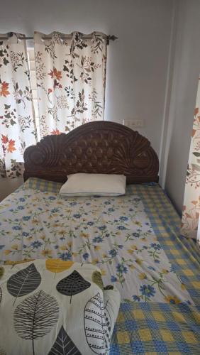 a bed with a wooden headboard and a blanket at Cozy apartment in jodhpur park, kolkata in Kolkata